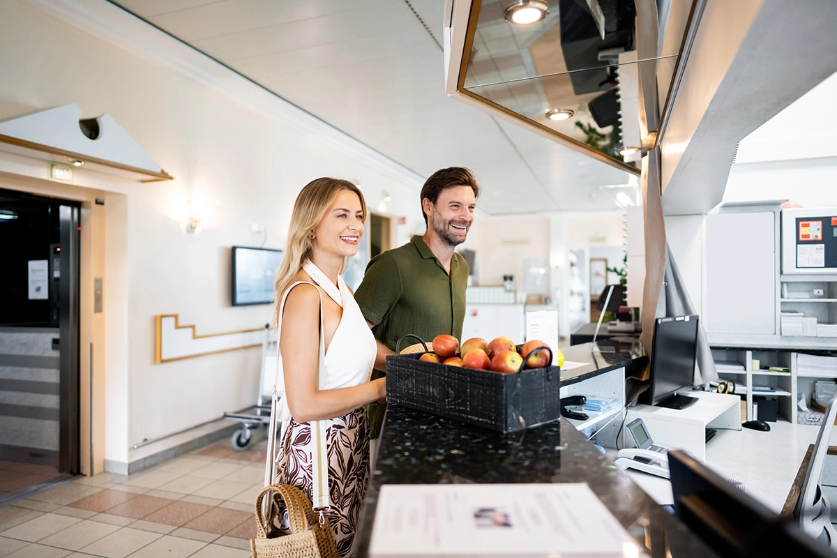 Eine Frau und ein Mann stehen an der Rezeption