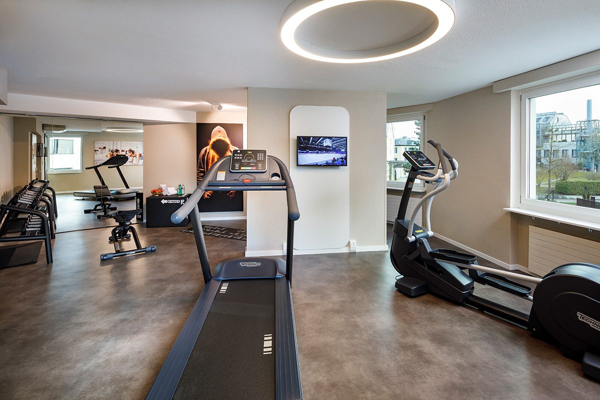 Fitnessraum mit Laufband, Crosstrainer und weiteren Sportgeräten