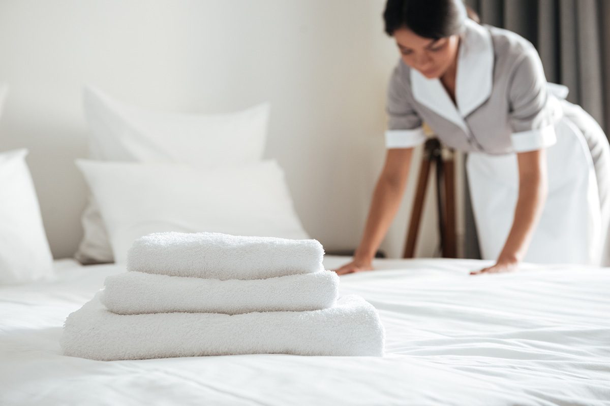 Zimmerservice mit Zimmermädchen beim Bett machen und Handtuchwechsel
